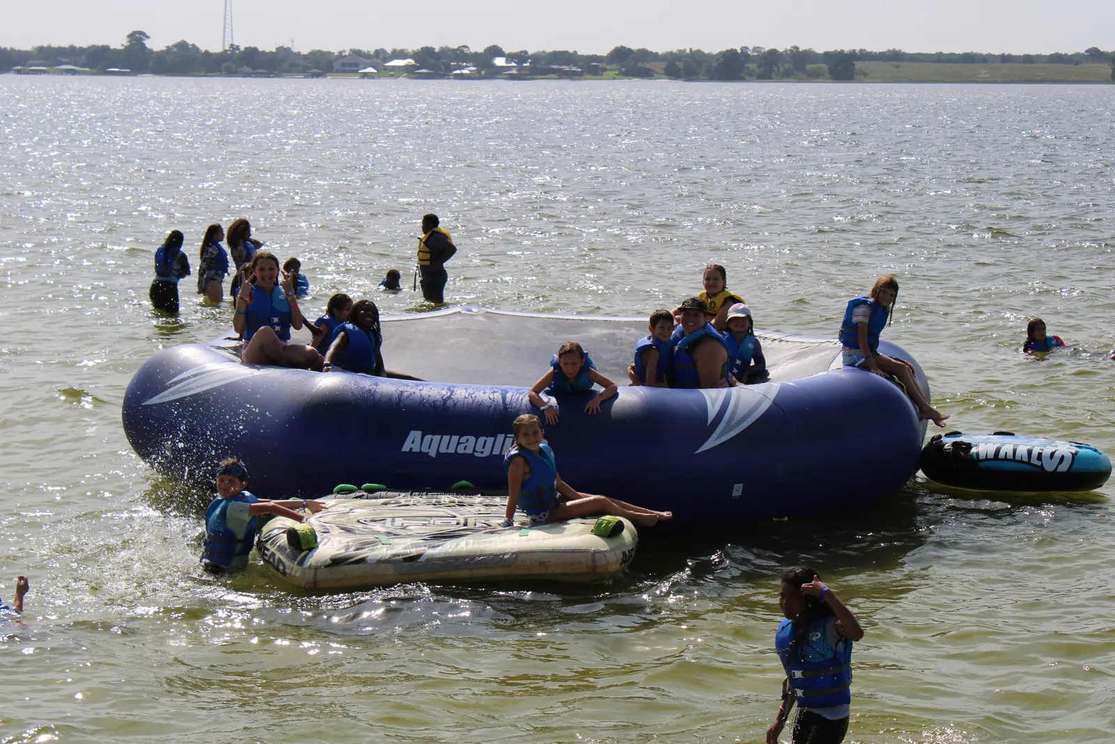 Campers floating on a big inflatable out on the lake