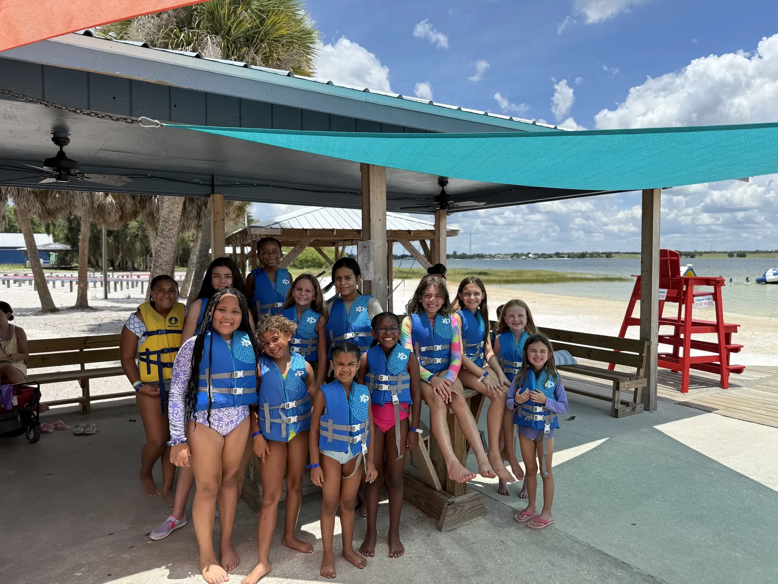 Campers in life jackets lined up under the waterfront pavilion