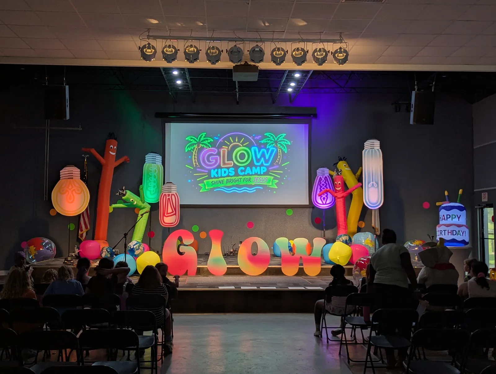 The GLOW chapel stage lit up in neon colors