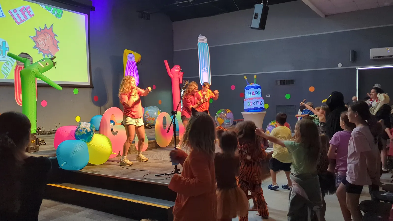 Leaders and kids leading worship on stage