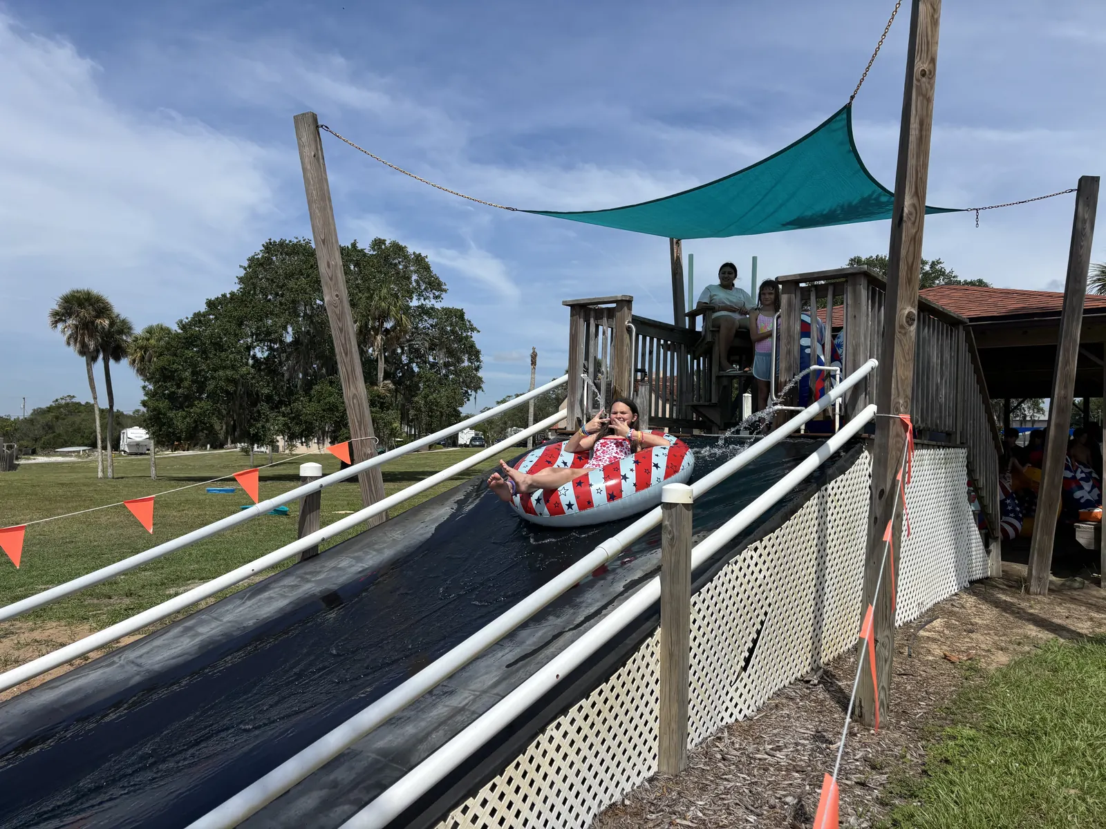 A camper zooming down the waterslide on a tube