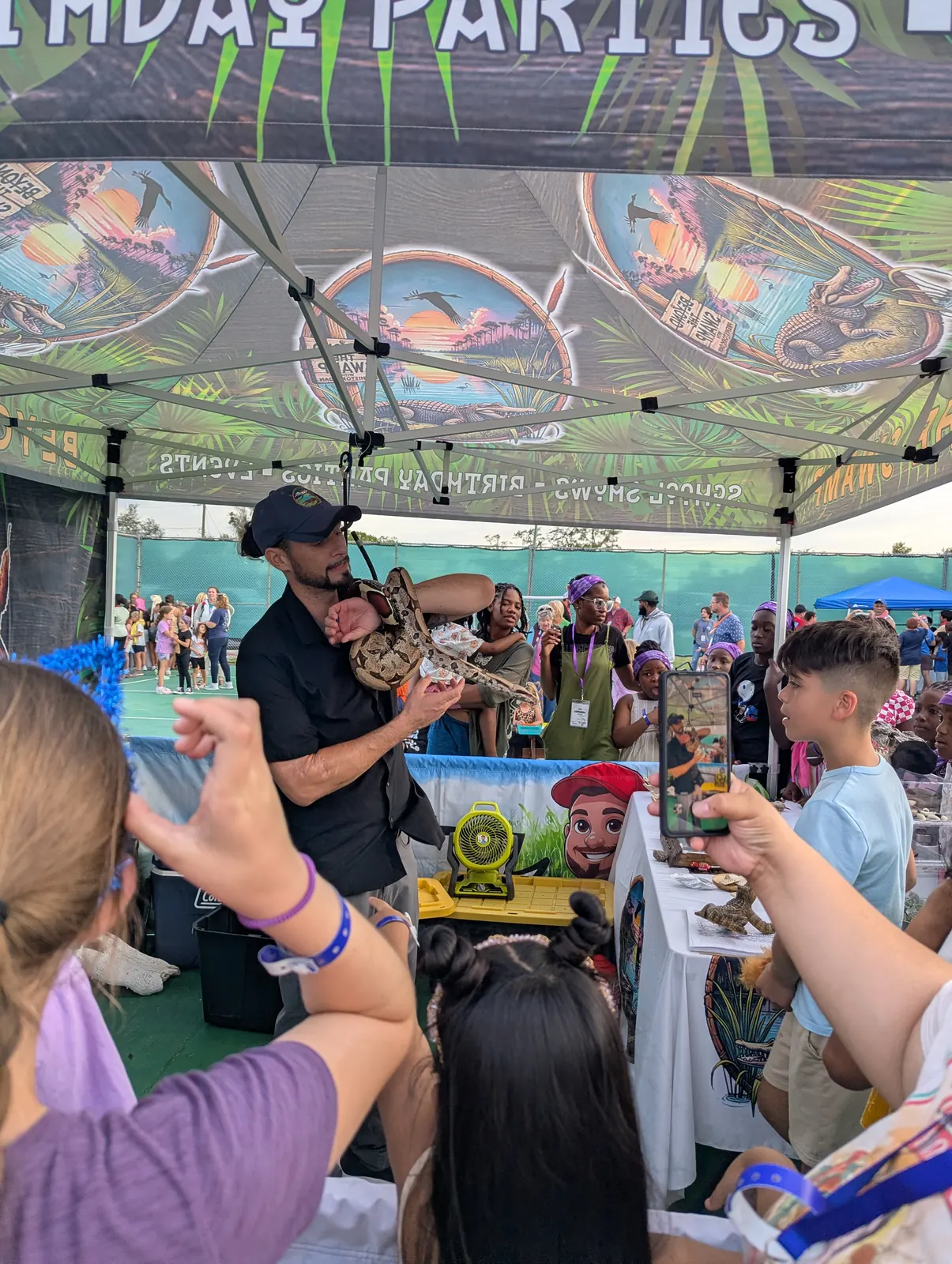 An animal handler showing a reptile to campers
