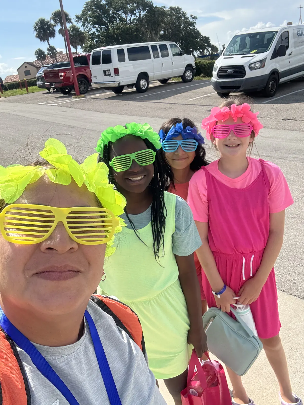 A leader and campers in neon glasses for theme night